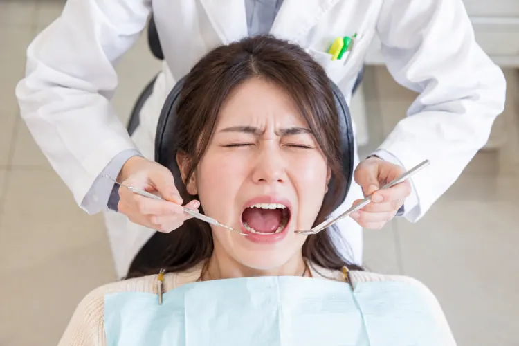 口を大きく開けてつらそうな女性