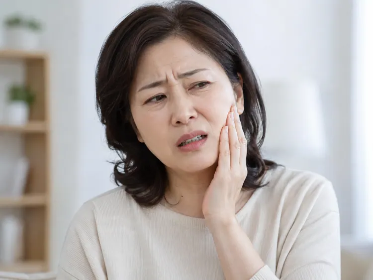 頬を押さえて痛がる女性